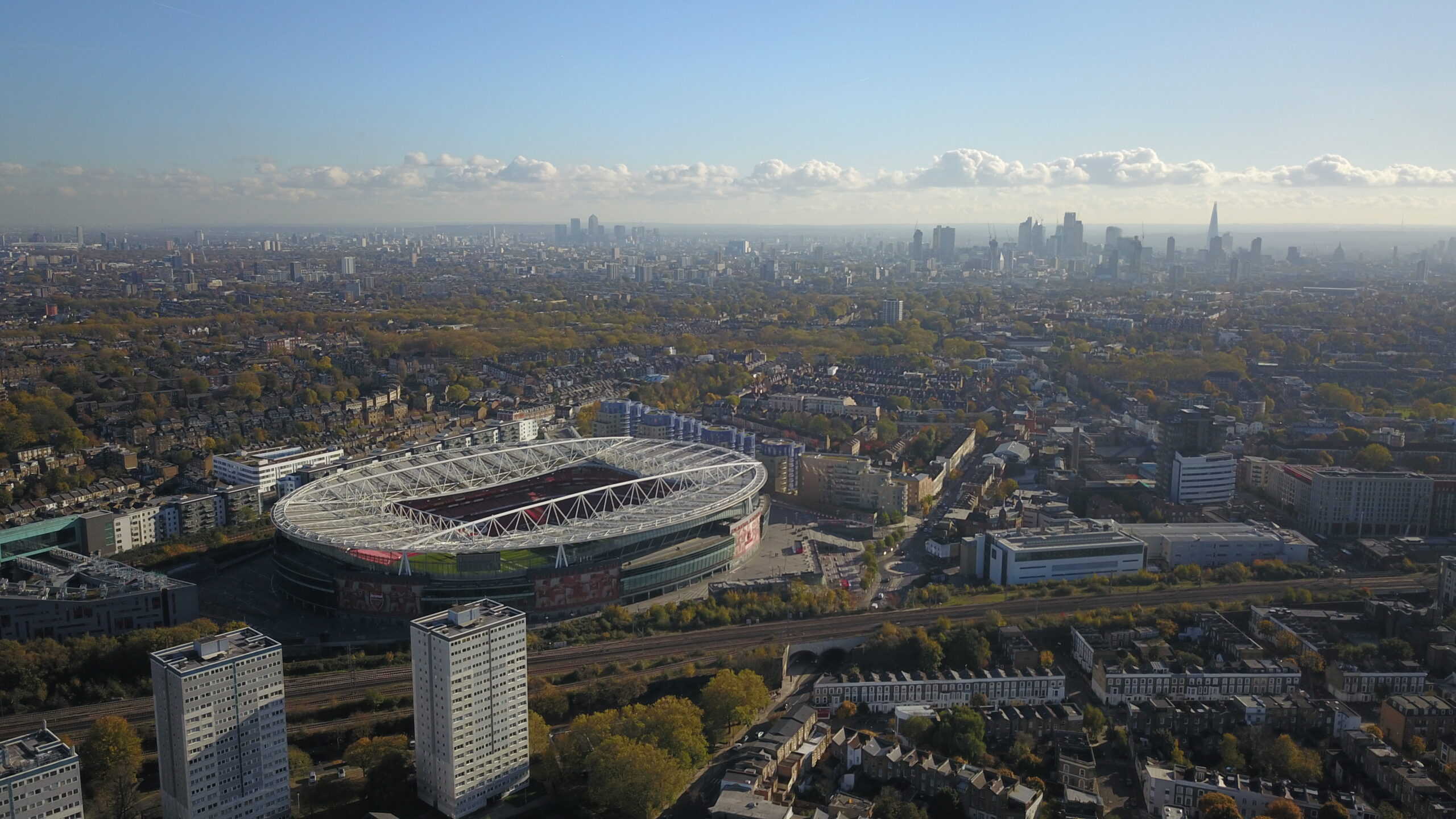 Ariel shot of the Emirates Stadium with the London skyline in the background